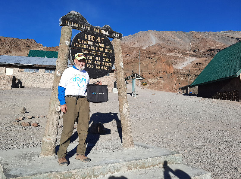 Ski standing in front of Mt Kilimanjaro sign for Kibu Hut