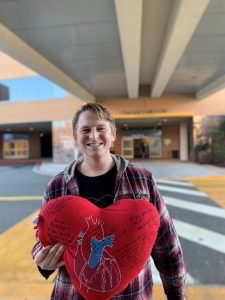 Joey leaving the hospital, holding a stuffed heart
