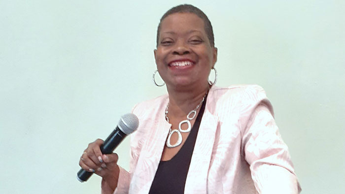 Lisa Baxter, holding a microphone, and smiling